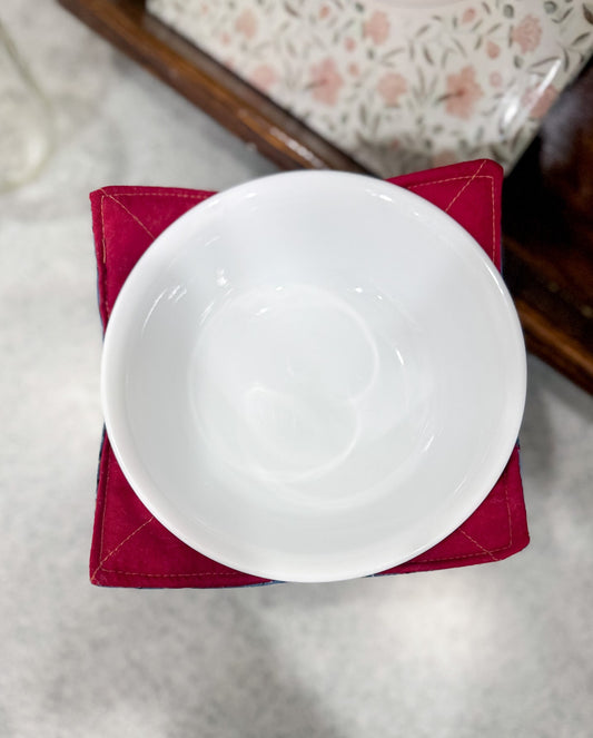 White bowl on a red napkin with a floral-patterned tablecloth in the background