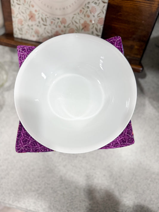 White ceramic bowl on a purple fabric surface
