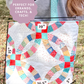 Colorful quilt with measurements and text overlay on a grassy background