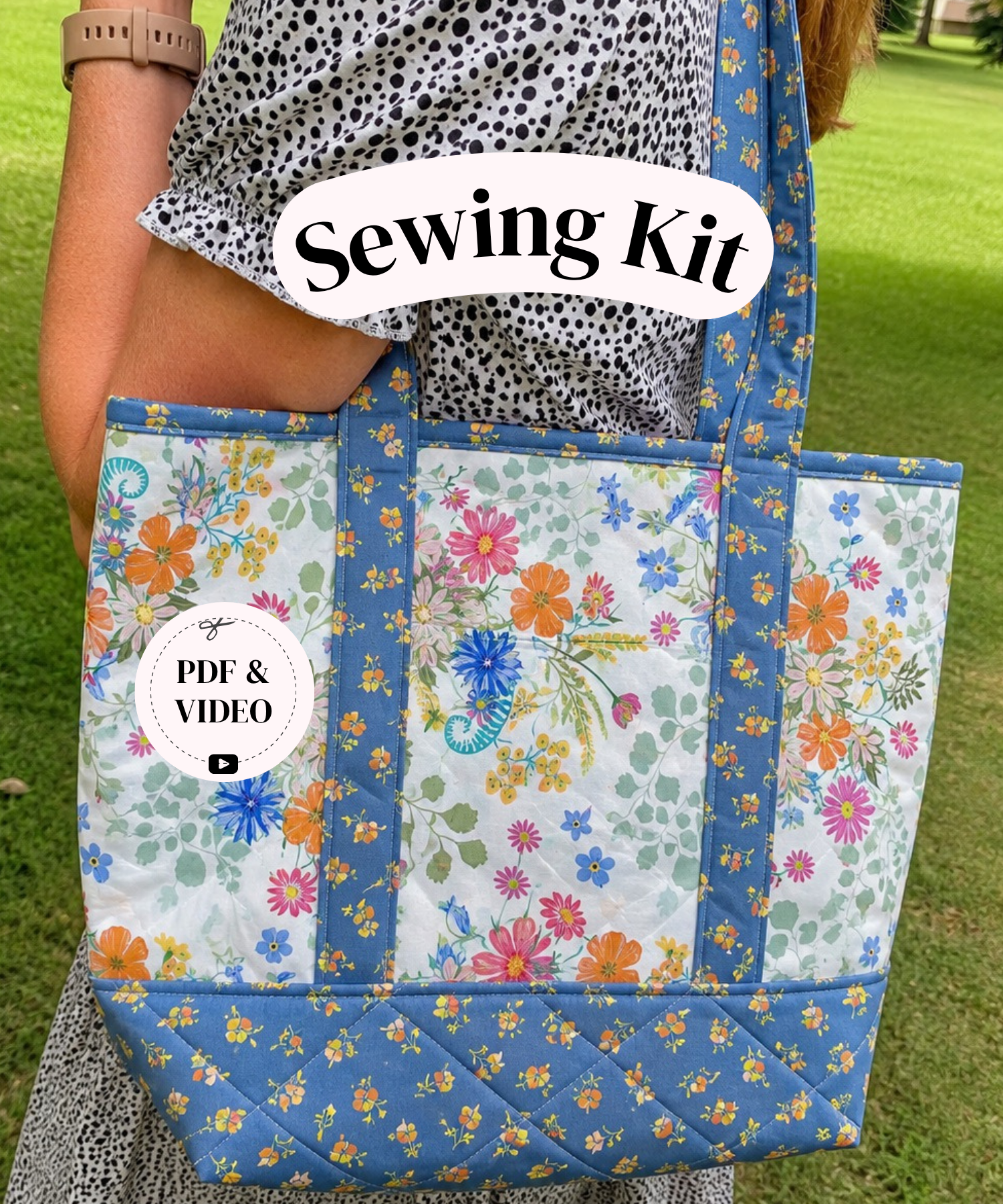 A person outdoors carrying a large quilted tote bag with a floral print. The bag has blue borders and handles, and the front panels show a multicolor floral pattern on a light background.