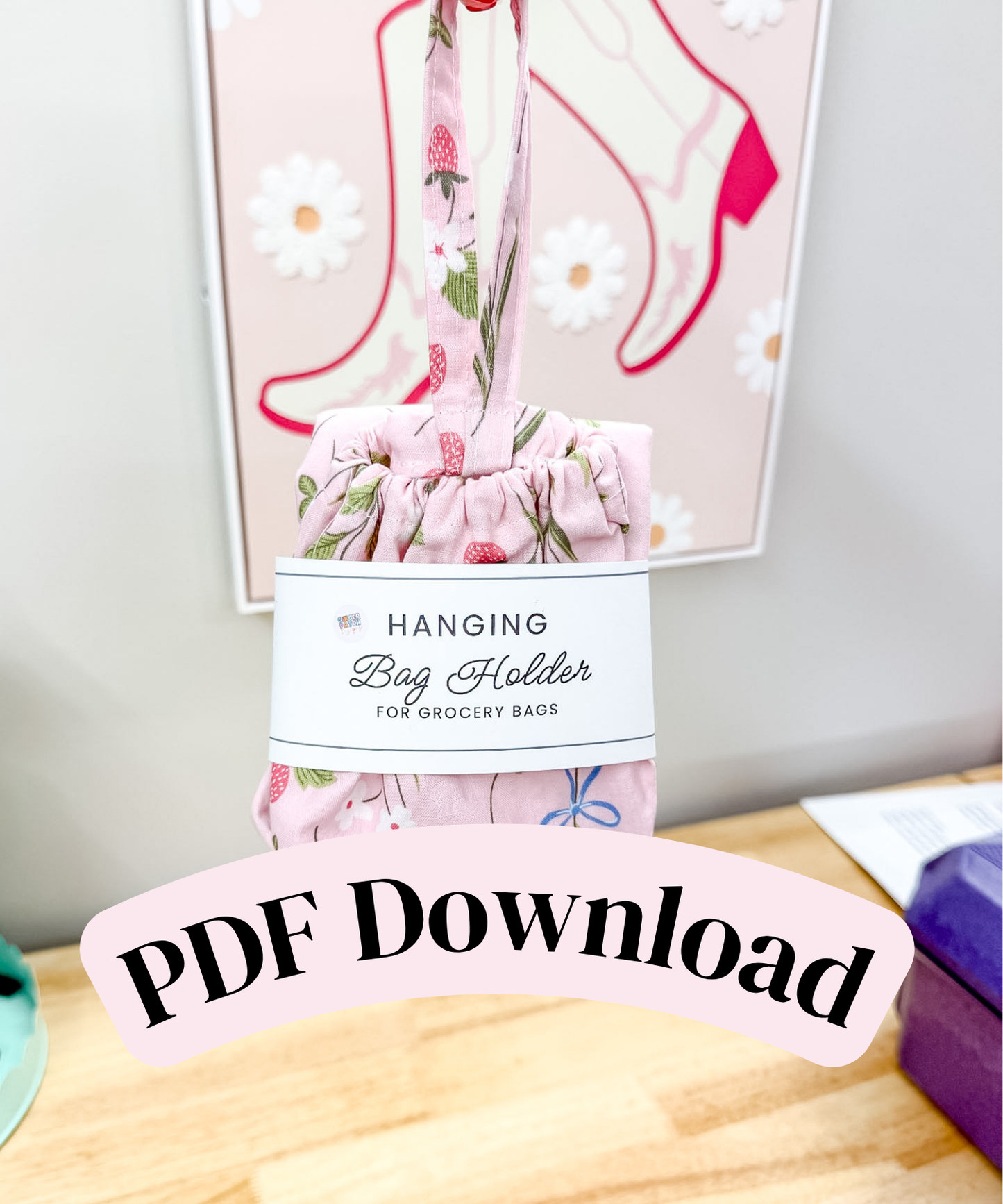 A pink floral hanging bag holder made of fabric, shown with a paper label that reads 'Hanging Bag Holder for Grocery Bags.' A large overlaid banner says 'PDF Download.