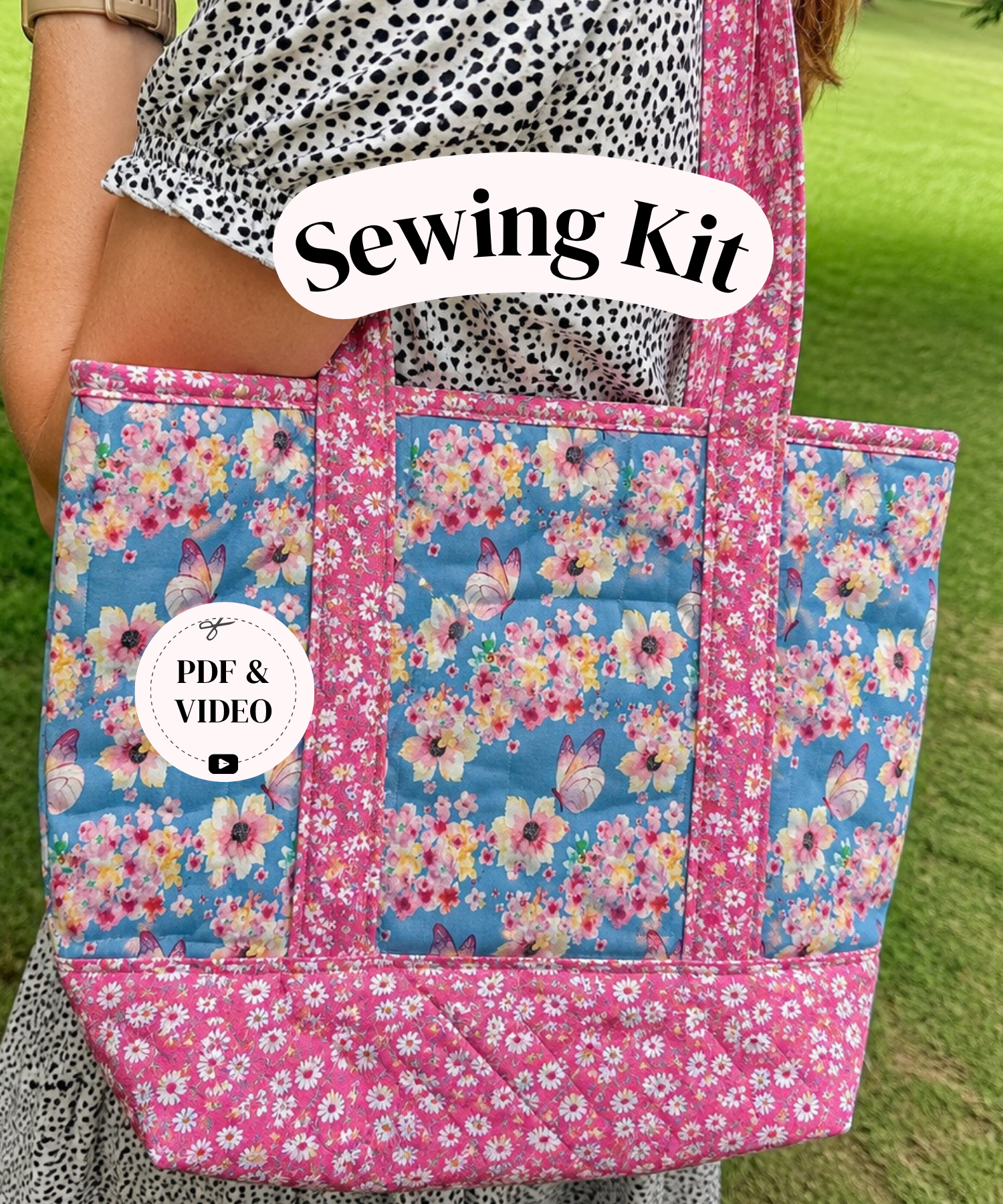 A person outdoors carrying a floral sewing tote bag. The bag has pink floral trim and panels with blue center panels featuring pink, yellow, and white flowers.