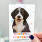 Magnetic bookmark with a dog illustration held by a hand against a blurred background