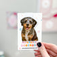 Dog-themed magnetic bookmark held by a hand with a blurred background