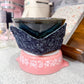 Pink ceramic dish with a blue floral patterned lid on a kitchen counter.