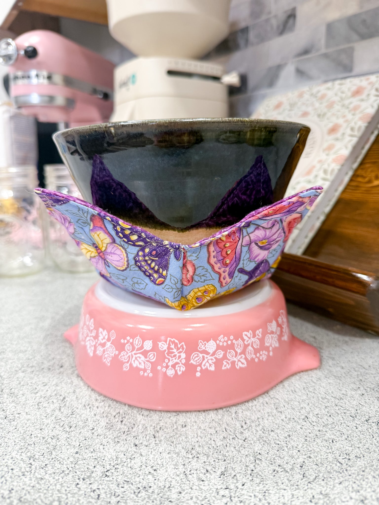Pink ceramic product with colorful butterfly design on a kitchen counter
