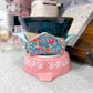 Ceramic bowl in floral pattern fabric bowl cozy on a pink base in a kitchen setting