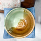 Ceramic bowl with a spiral design on a blue napkin