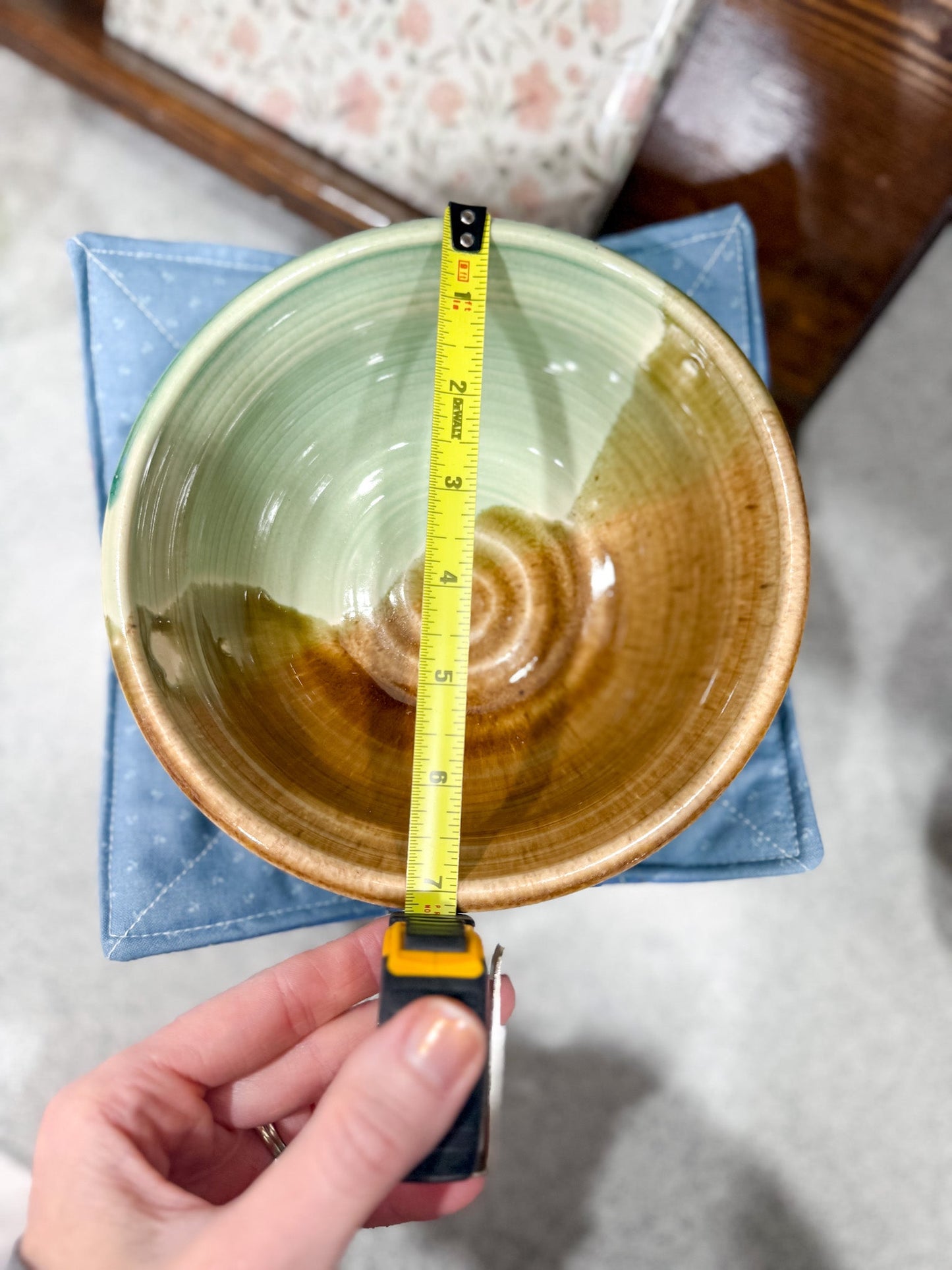 Ceramic bowl with a measuring tape for scale on a textured surface