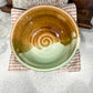 Ceramic bowl with a spiral design on a textured surface