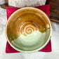 Ceramic bowl with a spiral design on a red napkin