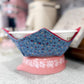 Decorative bowl with floral pattern on a pink base on a gray surface