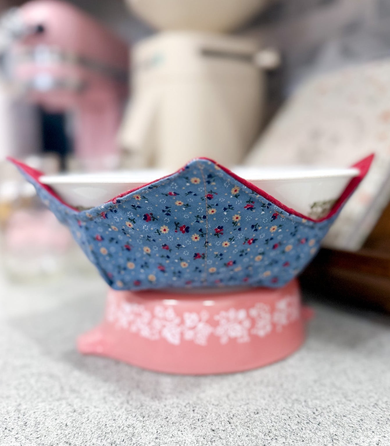 Decorative bowl with floral pattern on a pink base on a gray surface