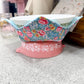 Pink bowl with floral fabric cover on a speckled countertop