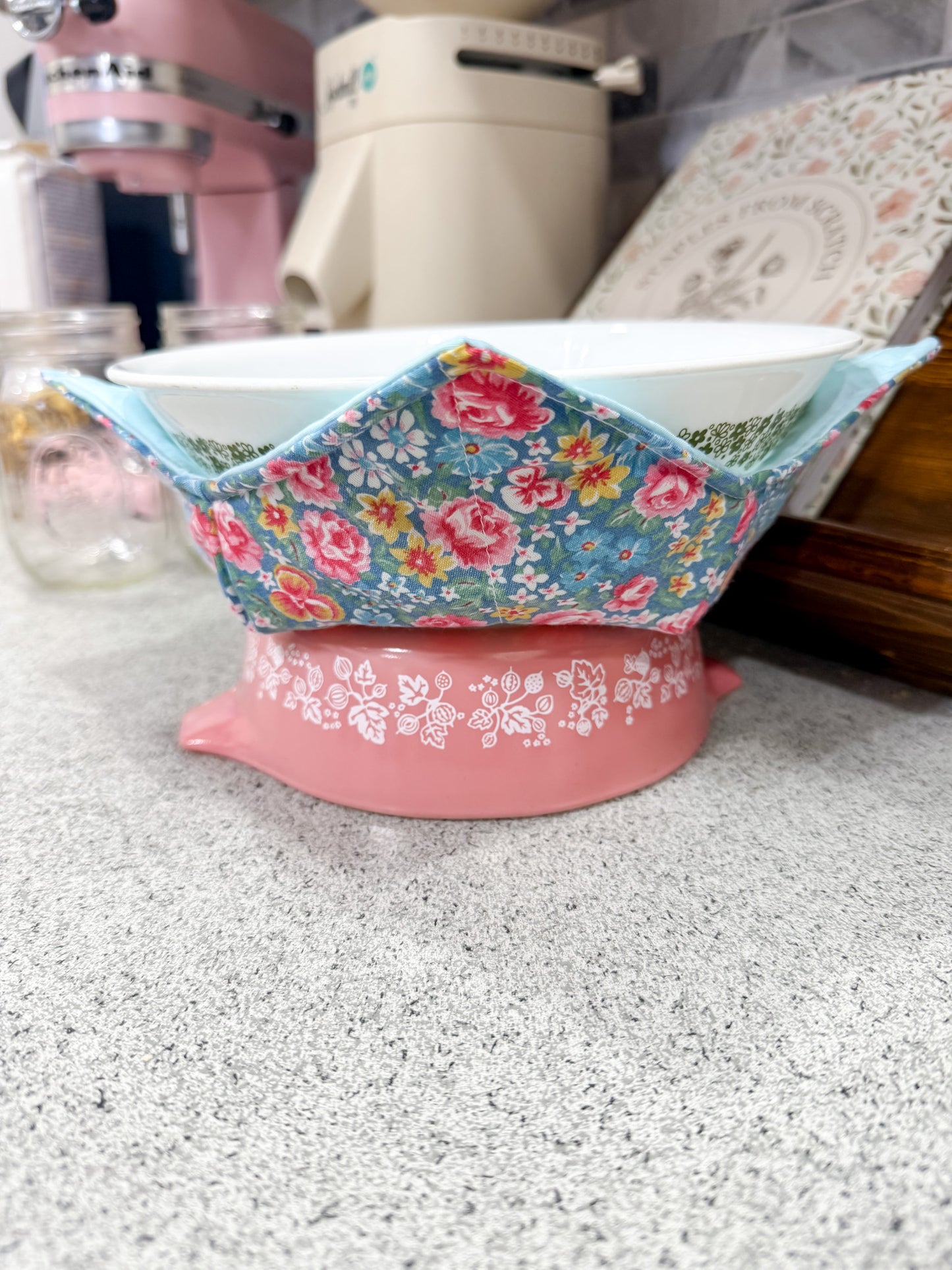 Pink bowl with floral fabric cover on a speckled countertop