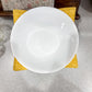White ceramic plate on a yellow coaster with a floral-patterned napkin in the background.