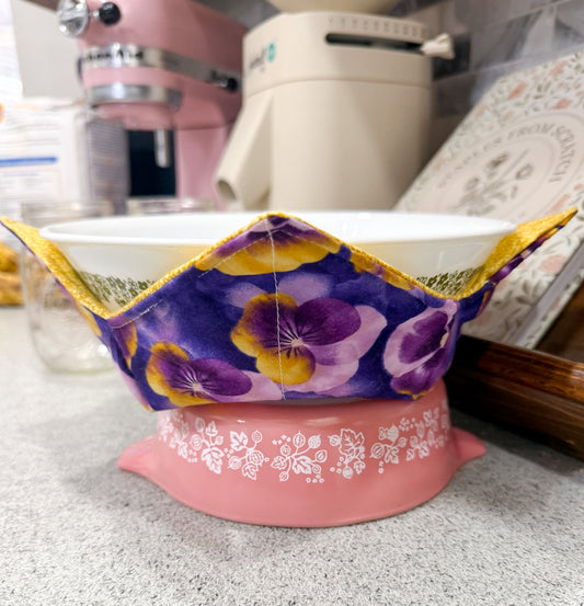 Pink kitchen scale with floral-patterned lid on a speckled countertop