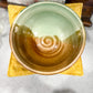 Ceramic bowl with gradient color on a yellow cloth