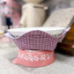 Pink and white floral-patterned dish on a gray surface