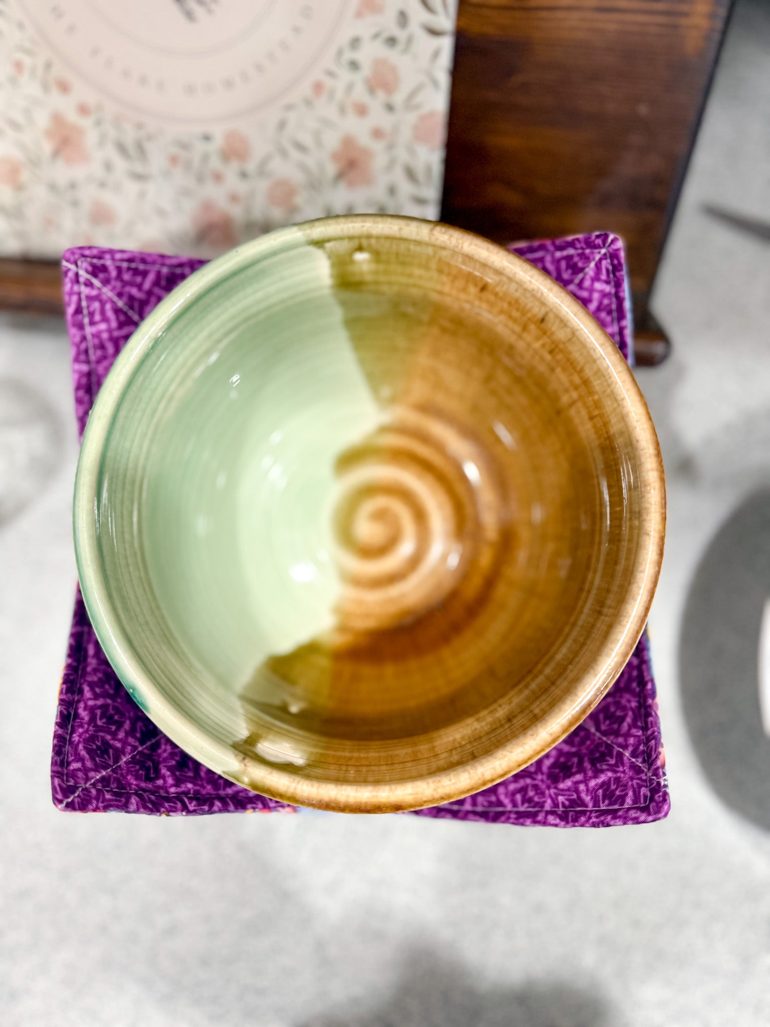 Ceramic bowl with a spiral design on a purple coaster