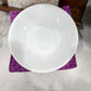 White ceramic bowl on a purple fabric surface