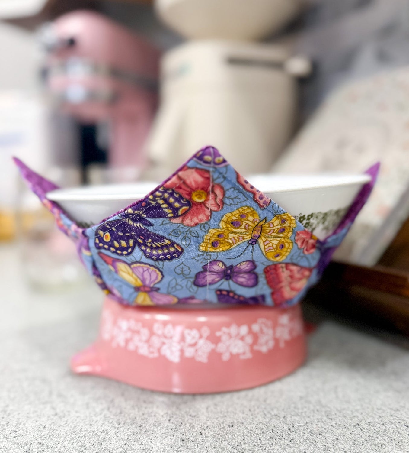 Colorful butterfly-patterned fabric on a white bowl with a pink base.