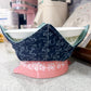Blue floral-patterned bowl on a pink stand with kitchen items in the background