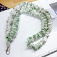 Green scrunchie on a white surface with a ruler for scale