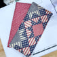 Quilted fabric samples on a cutting mat with a sewing machine in the background