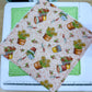 Fabric with garden-themed pattern on a cutting mat with a ruler