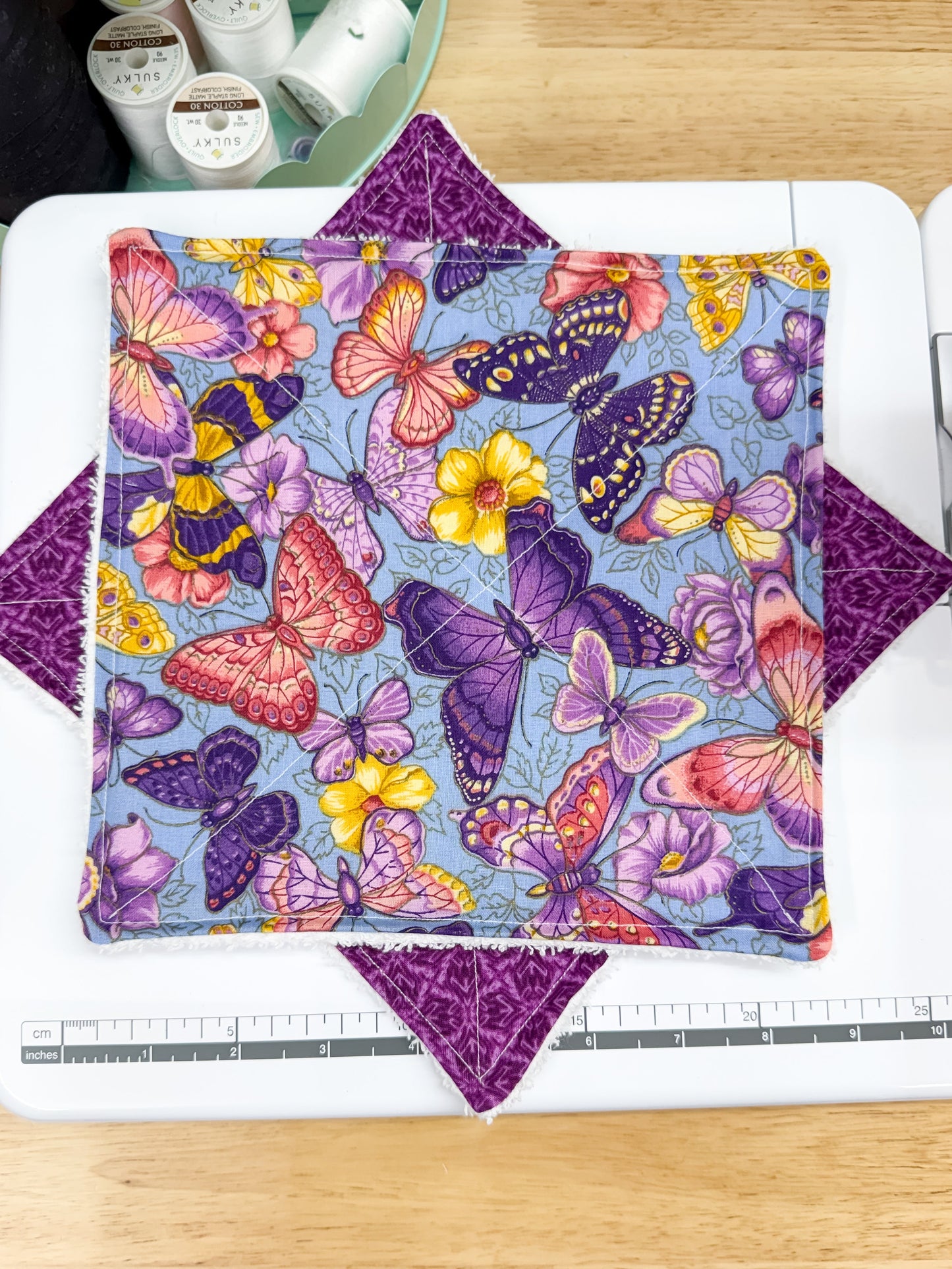 Colorful butterfly patterned fabric on a cutting mat with a ruler