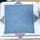 Blue quilted square with floral corners on a sewing machine