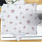 Floral fabric on a sewing machine with sewing supplies in the background