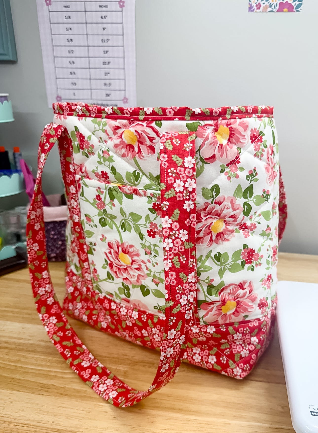 Floral fabric bag on a wooden surface with a printer in the background