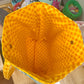 Yellow mesh bag on a wooden surface with a kitchen background