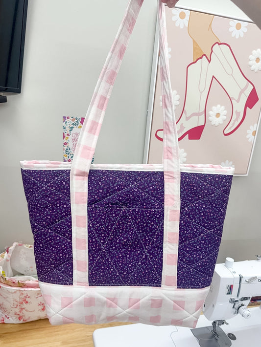 Purple and pink tote bag with glittery texture on a sewing machine table.