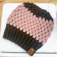 Knitted beanie with pink and brown gradient on a wooden surface