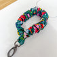 Multicolored scrunchie keychain on a white surface with a wooden background