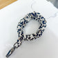 Leash with a blue and white pattern on a white surface with a ruler for scale.