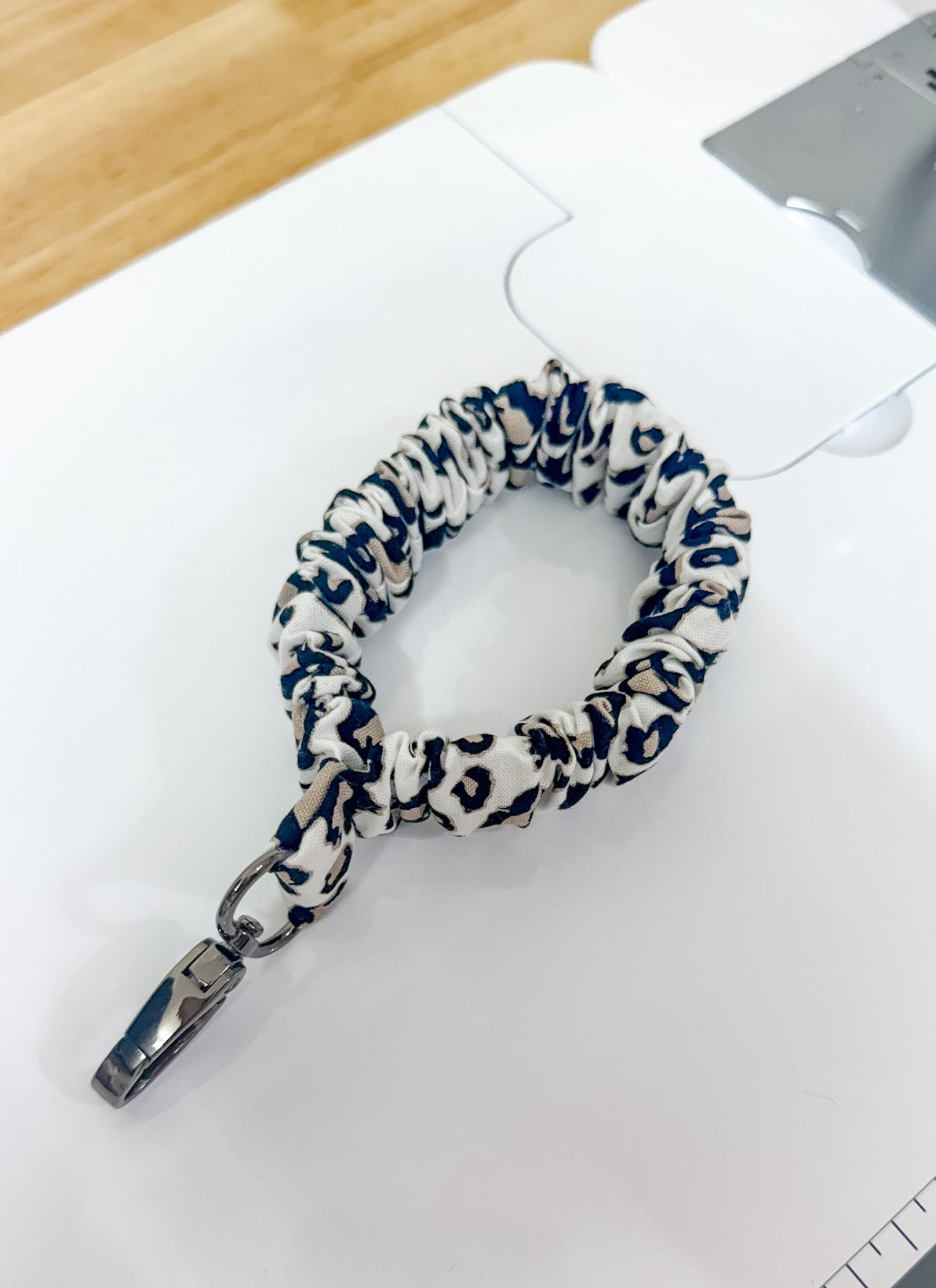 Leash with a blue and white pattern on a white surface with a ruler for scale.